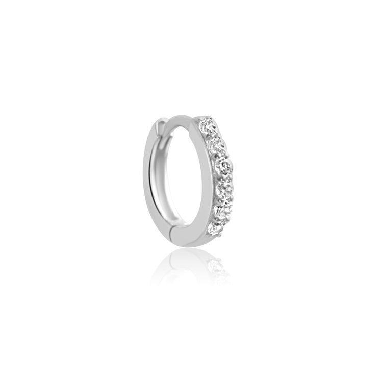 The CHLUXE Crystal Huggie Hoop by Crystal Heaven London is a 14K white gold earring embellished with small, clear cubic zirconia gemstones against a plain white backdrop.