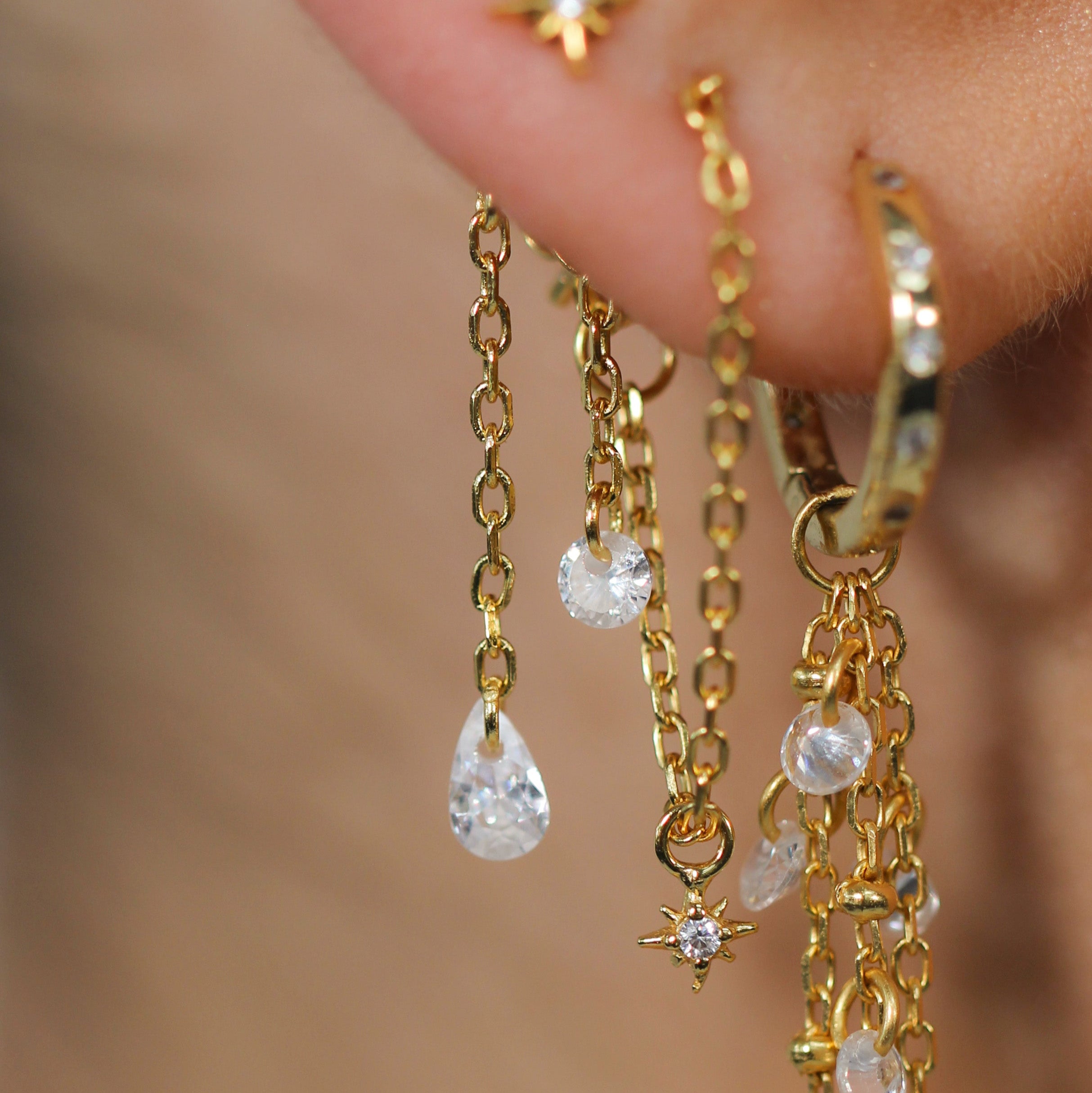 Close-up of the KAIA Floating Charm by Crystal Heaven London, a 925 silver hoop with dangling chains.