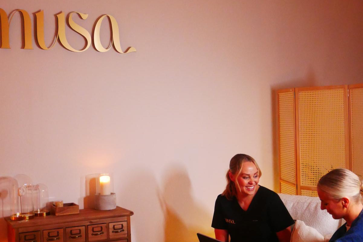 Two women in a piercing studio having an ear styling consultation.